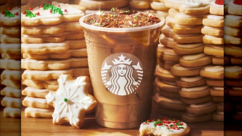 An Iced Sugar Cookie Almondmilk Latte from Starbucks surrounded by sugar cookies