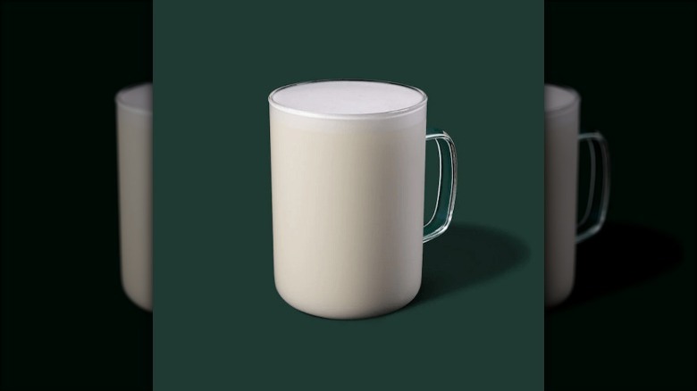 Steamed milk on green background