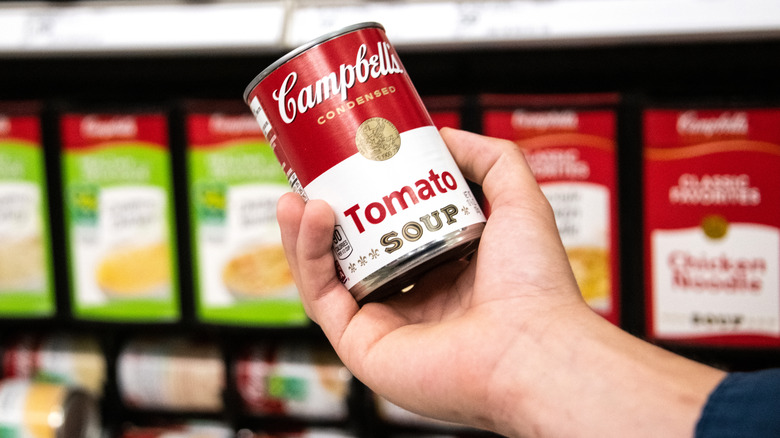 Hand holding a can of Campbell's tomato soup