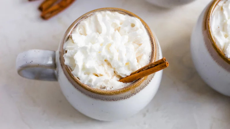 Coffee with whipped cream and cinnamon stick