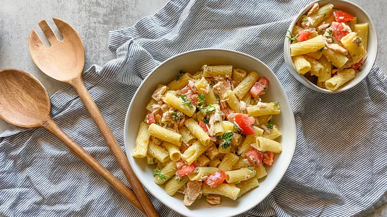 Tuna pasta with tomatoes and wooden utensils