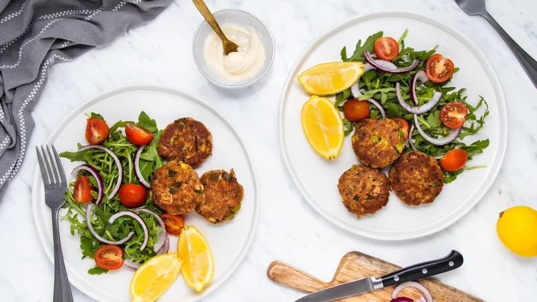 Tuna patties with lemon, salad, and sour cream