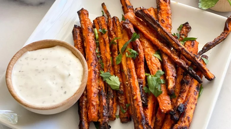 Plate of crispy carrot fries with bowl of Ranch dressing 