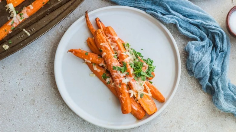 Plate of roasted carrots covered in Parmesan