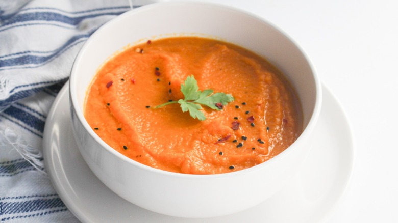 Bowl of carrot soup with sprig of parsley