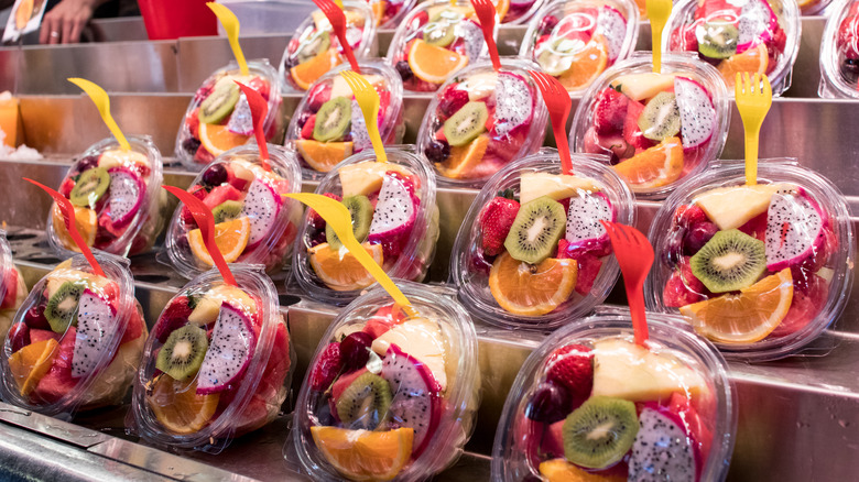 Plastic boxes of sliced fruit