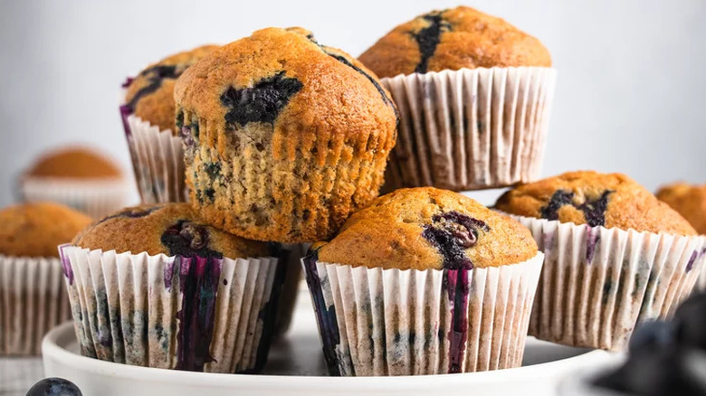 Plate with pile of baked blueberry muffins.