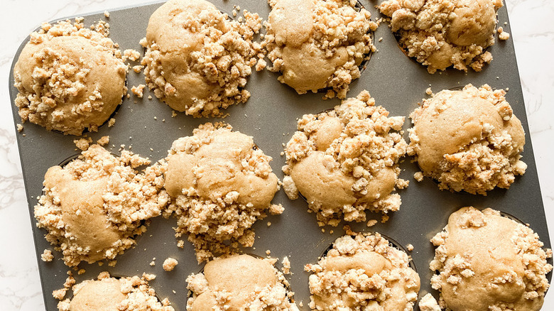 Baked muffins in a pan with crumbly topping. 