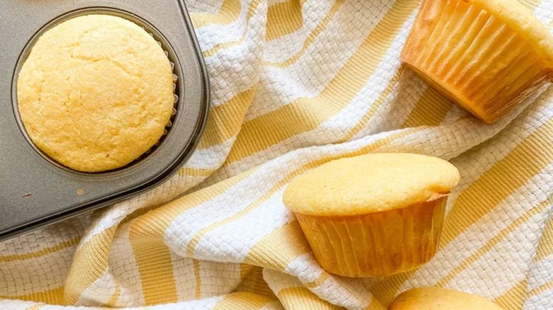 Baked corn muffins, one still in the pan. 