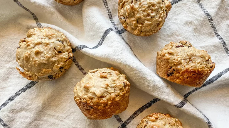 Baked oatmeal raisin muffins on a white and blue cloth.