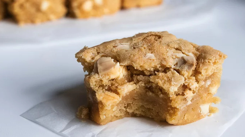 Blondie square with white chocolate chunks and a bite out.