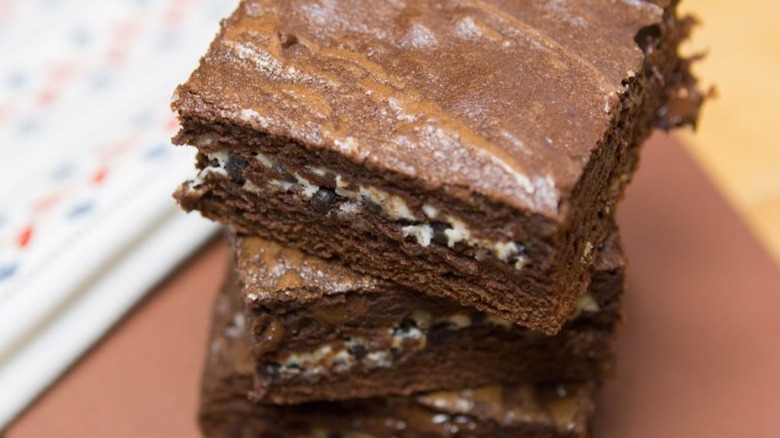 Stack of brownies with white chocolate layer in centers.