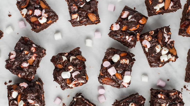 Square brownies topped with marshmallows and nuts.