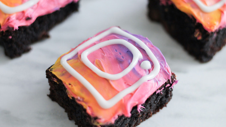 Brownies with pink/orange frosting and white details.