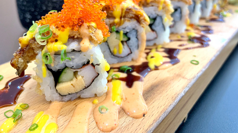 Makii roll drizzled with sauce and mayo and tobiko