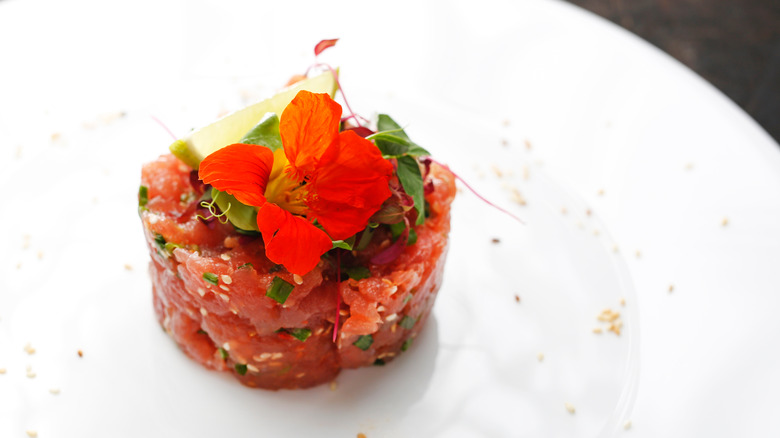 Tuna tartare with sesame seeds on white plate