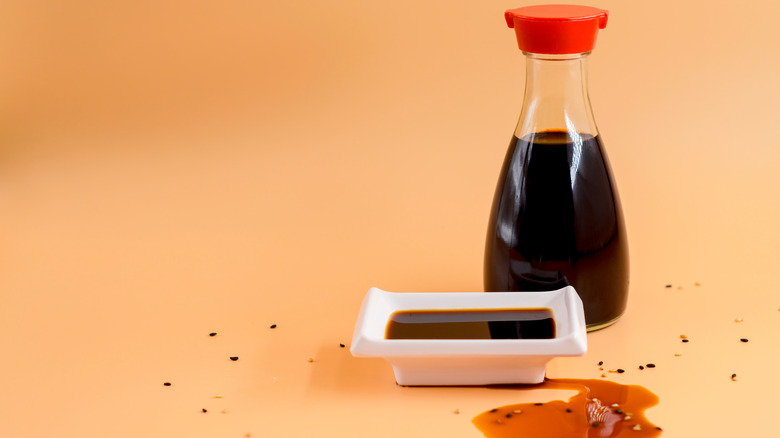 soy sauce in dish, container for pouring and on counter