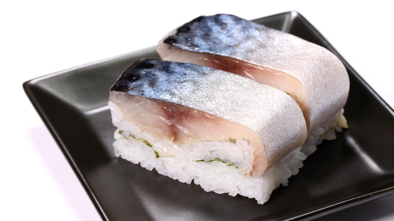 Pressed mackerel sushi on black square plate