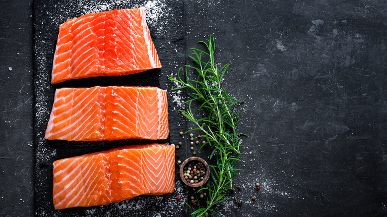 wild salmon fillets on slate with herb