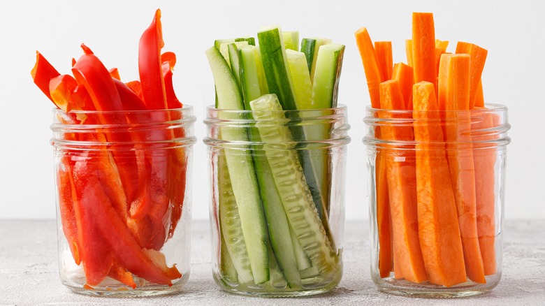 carrots batons, cucumber and red pepper in jars