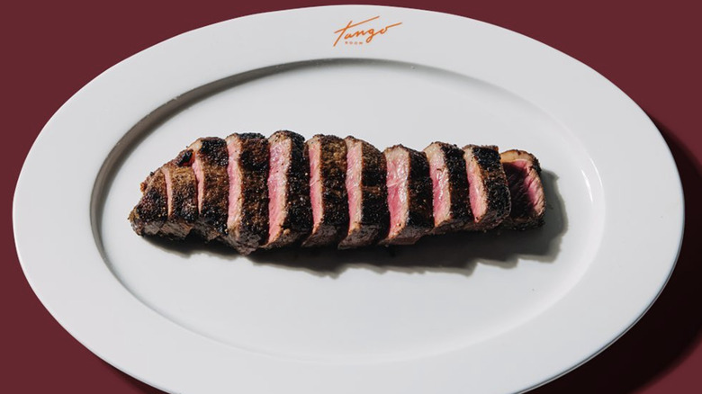 Cut steak filet on white Tango logo plate