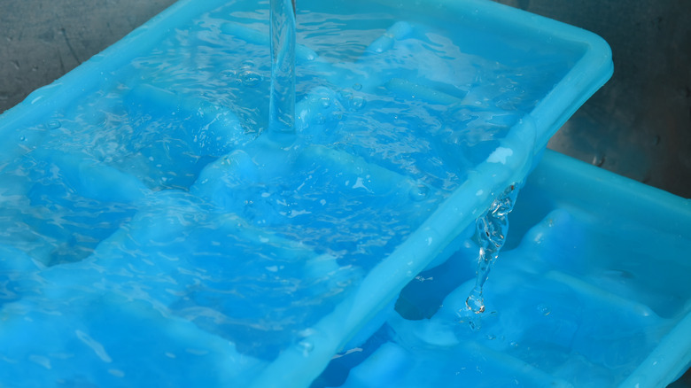 ice cube trays with pouring water