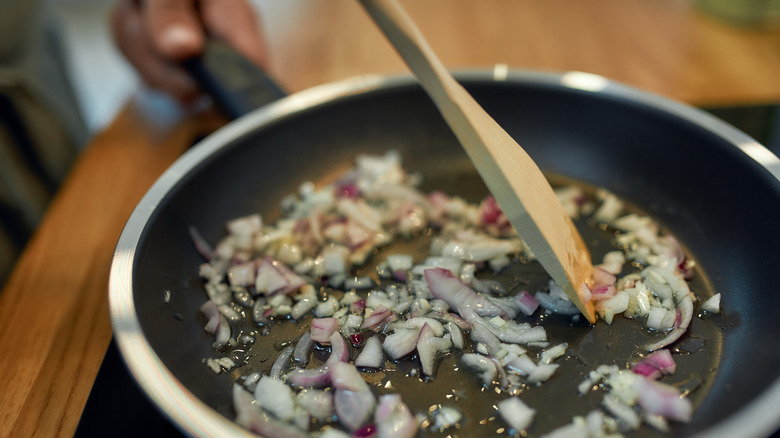 onions frying in a pan with spoon