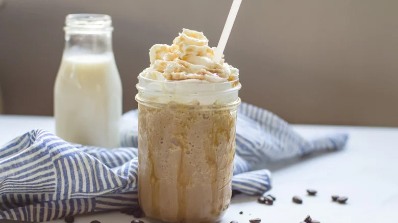 Copycat Starbucks Caramel Frappuccino wtih straw and jar of milk