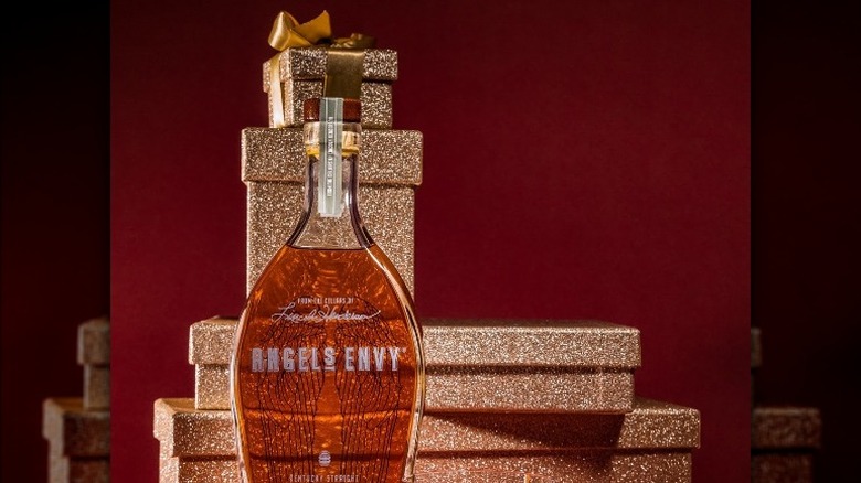 bottle of Angel's Envy against several gold gift boxes