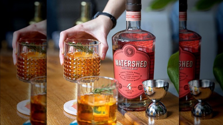 bottle of Watershed Bourbon with glasses and garnish