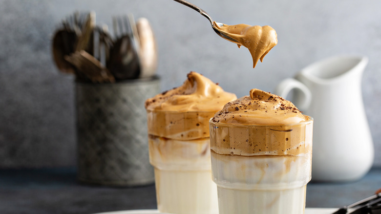 Glasses with milk topped with thick whipped coffee