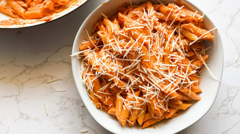 Bowl of pasta with sauce and shredded cheese