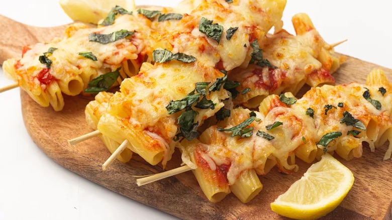 Rigatoni pasta on skewers with cheese and basil