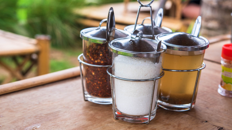 chili flakes and condiments on table