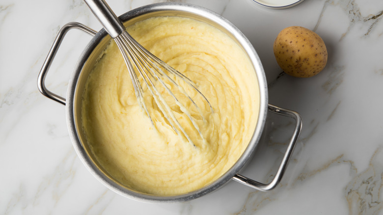 mashed potato in pan with whisk