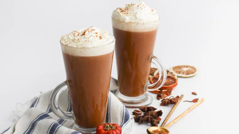 Two lattes with whipped cream and spices