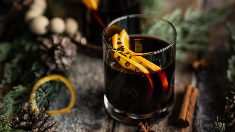 A cup of red wine with orange slices and cloves