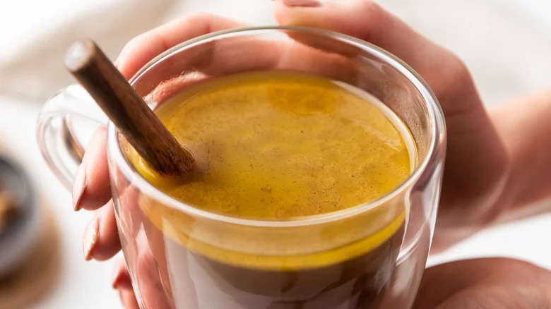 Woman holding a cup of buttered rum