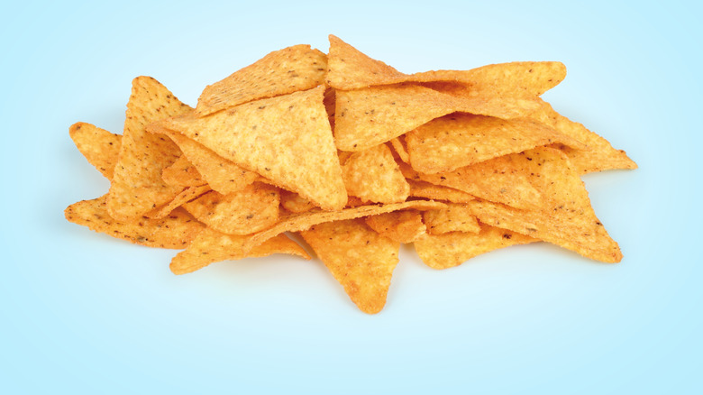 Doritos chips in pile against blue background