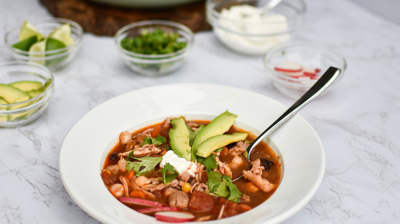 Chicken soup with sliced avocado