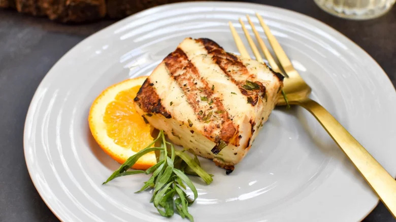 Grilled thick fillet with orange slice and tarragon