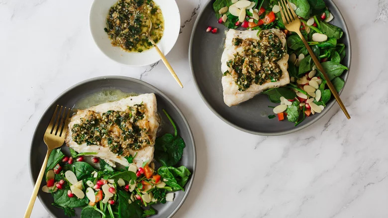 White fish with buttery herb topping and salad