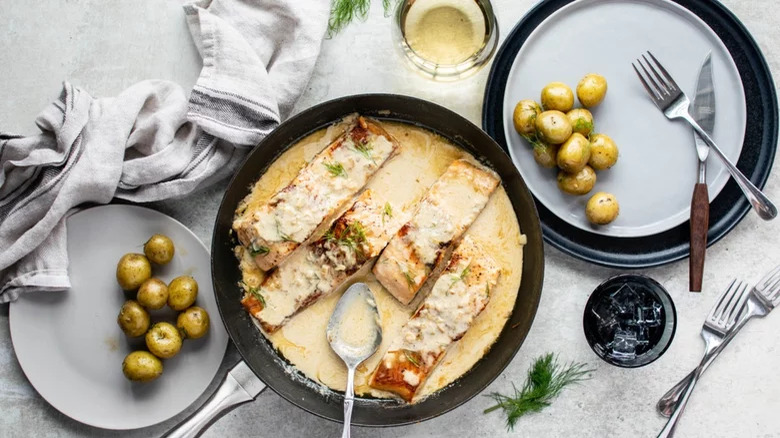 Salmon in pan with cream sauce and new potatoes