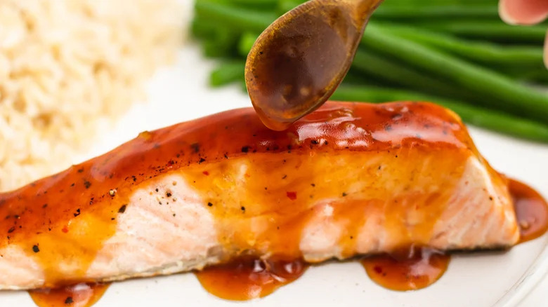 Soy glaze spooned on salmon fillet