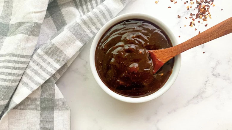 Barbecue sauce in bowl with wooden spoon