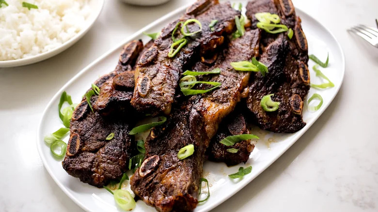 Beef ribs on plate with rice and garnish