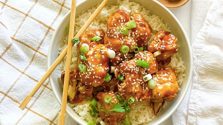 Sticky coated cauliflower on rice with chopsticks