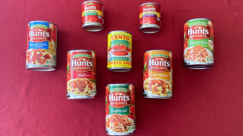 cans of spaghetti sauce on red background