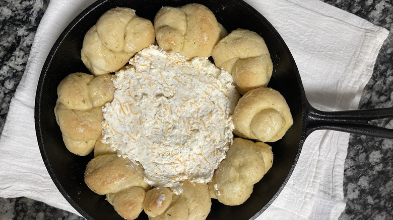 bread knots and cheese in a black frying pan