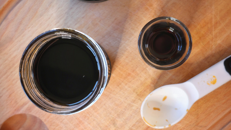 overhead shot of a jar and shotglass with coffee liqueur in them and an empty tablespoon measure